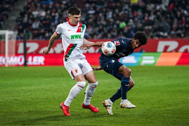 Fussball: Deutschland: 1. Bundesliga 2025 2026 - 29. Spieltag, 10.04.2026 - FC Augsburg vs. TSG Hoffenheim - WWK Arena (Augsburg, Deutschland); Mert Komur (FC Augsburg), Bernardo (TSG Hoffenheim) *** Soccer Germany 1 Bundesliga 2025 2026 Matchday 29, 10 04 2026 FC Augsburg vs TSG Hoffenheim WWK Arena Augsburg, Germany Mert Komur FC Augsburg , Bernardo TSG Hoffenheim Copyright: xLUKAxKOLANOVICx