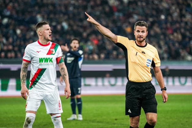 Fussball: Deutschland: 1. Bundesliga 2025 2026 - 29. Spieltag, 10.04.2026 - FC Augsburg vs. TSG Hoffenheim - WWK Arena (Augsburg, Deutschland); Jeffrey Gouweleeuw (FC Augsburg) bekommt von Schiedsrichter Daniel Schlager die gelbe Karte *** Soccer Germany 1 Bundesliga 2025 2026 Matchday 29, 10 04 2026 FC Augsburg vs TSG Hoffenheim WWK Arena Augsburg, Germany Jeffrey Gouweleeuw FC Augsburg gets a yellow card from referee Daniel Schlager Copyright: xLUKAxKOLANOVICx