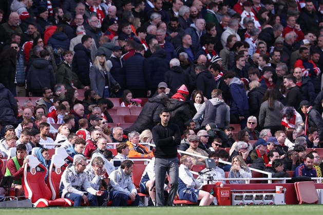 11th April 2026; Emirates Stadium, London, England; Premier League Football, Arsenal versus Bournemouth; Arsenal manager Mikel Arteta in the second half injury team as Arsenal fans can be seen leaving behind him KatiexChan