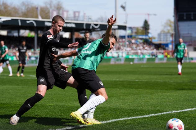 April 11, 2026, Muenster, Germany: SpVgg Greuther Fuerth midfielder BRYNJAR INGI BJARNASON (25) against SC Preussen Muenster defender YASSINE BOUCHAMA (5) during the match between SC Pruessen Muenster and SpVgg Greuther Fuerth in the 2. Bundesliga on April 11, 2026, in Muenster, Germany...DFL REGULATIONS PROHIBIT ANY USE OF PHOTOGRAPHS AS IMAGE SEQUENCES AND OR QUASI-VIDEO Soccer 2026: Pruessen Muenster 0:0 SpVgg Greuther Fuerth  - ZUMAc201 20260411_zap_c201_060 Copyright: xScottxColemanx