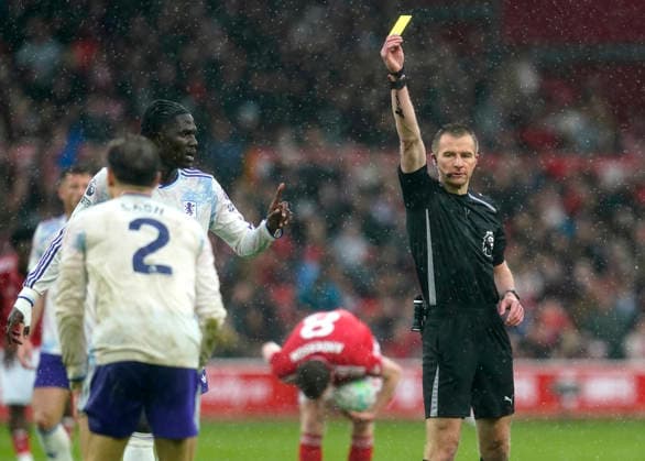 Nottingham, England, 12th April 2026. Matty Cash of Aston Villa (l) shown a yellow car by referee Michael Salisbury during the Nottingham Forest vs Aston Villa Premier League match at the City Ground, Nottingham. Picture credit should read: Andrew Yates Sportimage EDITORIAL USE ONLY. No use with unauthorised audio, video, data, fixture lists, club league logos or live services. Online in-match use limited to 120 images, no video emulation. No use in betting, games or single club league player publications. SPI_017_AY_Forest_Villa SPI-4682-0015