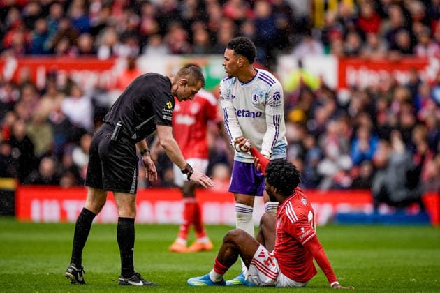 Premier League: Nottingham Forest v Aston Villa Referee Michael Salisbury checks on Ola Aina of Nottingham Forest who has one down with an injury and is helped to feet by Morgan Rogers of Aston Villa during the Premier League match Nottingham Forest vs Aston Villa at City Ground, Nottingham, United Kingdom on 12 April 2026 (Photo by Maynard Manyowa News Images) Nottingham City Ground Nottinghamshire United Kingdom Copyright: xMaynardxManyowa NewsxImagesx