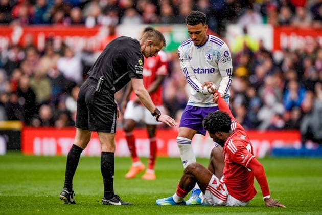 Premier League: Nottingham Forest v Aston Villa Referee Michael Salisbury checks on Ola Aina of Nottingham Forest who has one down with an injury and is helped to feet by Morgan Rogers of Aston Villa during the Premier League match Nottingham Forest vs Aston Villa at City Ground, Nottingham, United Kingdom on 12 April 2026 (Photo by Maynard Manyowa News Images) Nottingham City Ground Nottinghamshire United Kingdom Copyright: xMaynardxManyowa NewsxImagesx