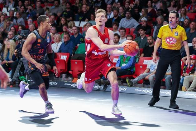 Justus Hollatz 21 (FC Bayern Muenchen Basketball), rechts, in Aktion gegen Eric Washington 33 (Niners Chemnitz), FC Bayern Muenchen Basketball vs. Niners Chemnitz, easyCredit BBL, Basketball, Bundesliga, Maenner, Hauptrunde, 12. April 2026 Muenchen Bayern Deutschland