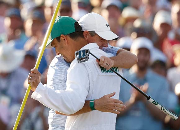 Rory McIlroy of Northern Ireland celebrates with his caddie Harry Diamond after winning the 2026 Masters Tournament at Augusta National Golf Club on Sunday, April 12, 2026, in Augusta, Georgia. McIlroy won his second consecutive Masters with a 12-under-par four-day score of 276.  AUG20260412878 JOHNxANGELILLO