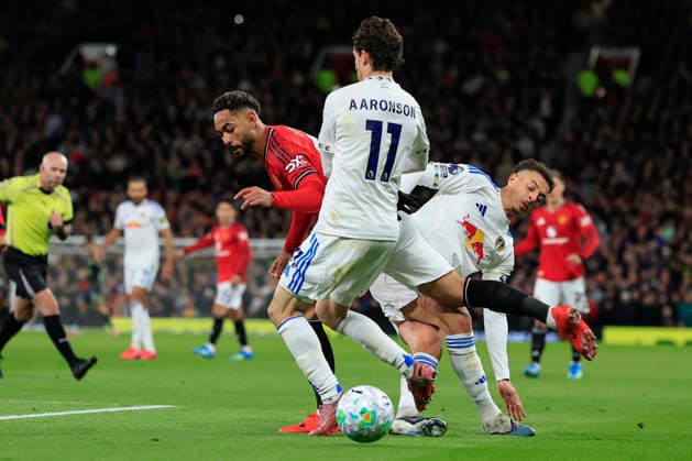 Manchester United, ManU v Leeds United, Premier League Matheus Cunha (10) of Manchester United goes down under challenge from Ethan Ampadu (4) and Brenden Aaronson (11) of Leeds United during the Premier League match between Manchester United and Leeds United at Old Trafford, Manchester, UK on 13 April 2026. Manchester Old Trafford Greater Manchester UK Editorial use only DataCo restrictions apply See www.football-dataco.com , Copyright: xConorxMolloyx PSI-24063-0133