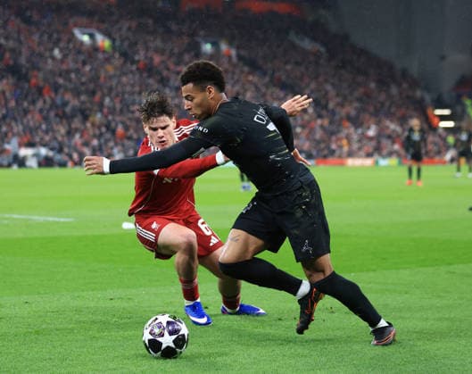 Liverpool, England, 14th April 2026. Milos Kerkez of Liverpool challenges Desire Doue of Paris Saint-Germainduring the Liverpool vs Paris Saint Germain UEFA Champions League quarter final 2nd leg match at Anfield, Liverpool. Picture credit should read: Jessica Hornby Sportimage EDITORIAL USE ONLY. No use with unauthorised audio, video, data, fixture lists, club league logos or live services. Online in-match use limited to 120 images, no video emulation. No use in betting, games or single club league player publications. SPI_082_JH_Liverpool_PSG SPI-4687-0081