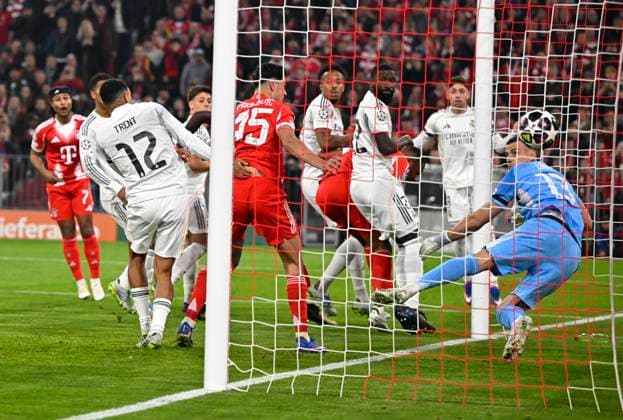 15.04.2026, Fussball UEFA Championsleague 2025 2026: Viertelfinale Rückspiel, FC Bayern München - Real Madrid, in der Allianz-Arena München, Aleksandar Pavlovic (FC Bayern München) trifft zum 1:1 gegen Torwart Andriy Lunin (Real Madrid)