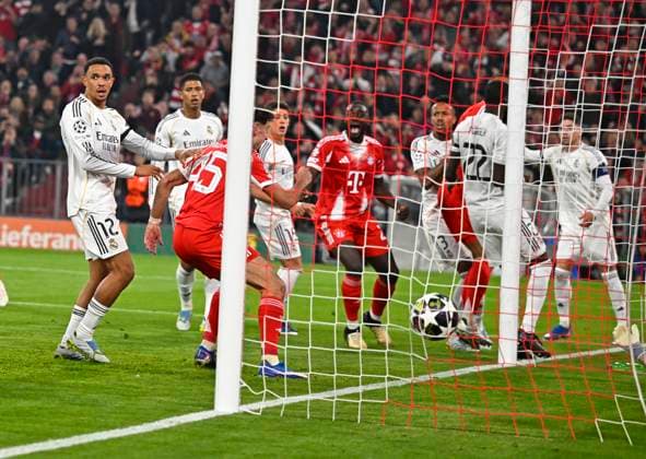 15.04.2026, Fussball UEFA Championsleague 2025 2026: Viertelfinale Rückspiel, FC Bayern München - Real Madrid, in der Allianz-Arena München, Aleksandar Pavlovic (FC Bayern München) trifft zum 1:1 gegen Torwart Andriy Lunin (Real Madrid)