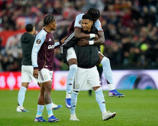 Birmingham, England, 16th April 2026. Ollie Watkins of Aston Villa is jumped upon by Tammy Abrahams of Aston Villa to celebrate the win during the Aston Villa vs Bologna UEFA Europa League quarter final 2nd leg match at Villa Park, Birmingham. Picture credit should read: Andrew Yates Sportimage EDITORIAL USE ONLY. No use with unauthorised audio, video, data, fixture lists, club league logos or live services. Online in-match use limited to 120 images, no video emulation. No use in betting, games or single club league player publications. SPI_064_AY_Villa_Bologna SPI-4689-0066