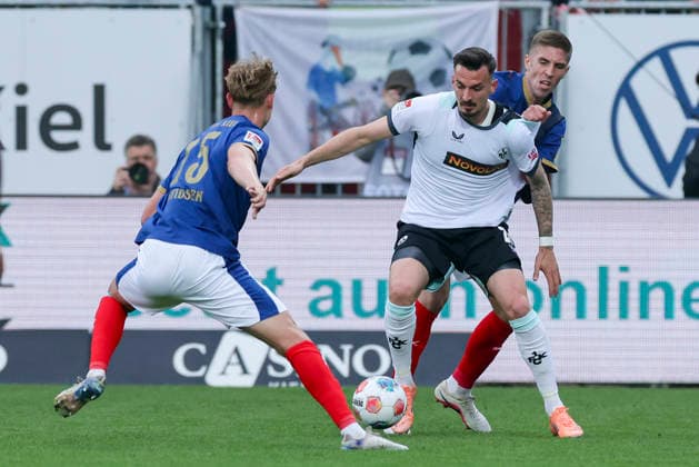 Kasper Davidsen (Holstein Kiel), Mergim Berisha (1. FC Kaiserslautern) und David Zec (Holstein Kiel) kaempfen um den Ball, 2. Bundesliga, Holstein Kiel v 1. FC Kaiserslautern, Holstein-Stadion am 17. April 2026 in Kiel, Deutschland. (Foto von Marco Steinbrenner DeFodi Images) Kasper Davidsen (Holstein Kiel), Mergim Berisha (1. FC Kaiserslautern) und David Zec (Holstein Kiel) battle for the ball, 2. Bundesliga, Holstein Kiel v 1. FC Kaiserslautern, Holstein-Stadion, April 17, 2026 in Kiel, Germany. (Photo by Marco Steinbrenner DeFodi Images) -