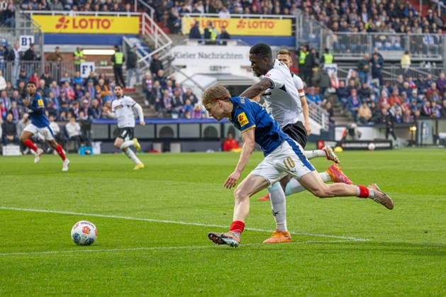 17.04.2026 Fußball 2. Bundesliga Männer Saison 2025 2026 30. Spieltag Holstein Kiel - 1. FC Kaiserslautern (Kiel in Blau, Kaiserslautern in Weiß) Bildmitte: Maxwell Gyamfi (hinten), Jonas Therkelsen Kiel Holstein Stadion, Westring 501 Schleswig Holstein Deutschland