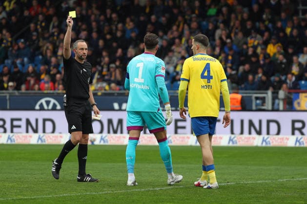 19.04.2026, Fußball, Herren, 2. BL, Saison 2025 2026, Eintracht Braunschweig vs. Hertha BSC Berlin: Schiedsrichter zeigt Torwart Ron-Thorben Hoffmann (Eintracht Braunschweig) die gelbe Karte (DFL DFB REGULATIONS PROHIBIT ANY USE OF PHOTOGRAPHS as IMAGE SEQUENCES and or QUASI-VIDEO) Stadion an der Hamburger Straße Niedersachsen Deutschland