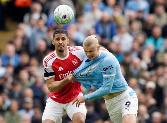 Manchester, England, 19th April 2026. William Saliba of Arsenal (l) tussles with Erling Haaland of Manchester City (r) during the Manchester City vs Arsenal Premier League match at the Etihad Stadium, Manchester. Picture credit should read: Andrew Yates Sportimage EDITORIAL USE ONLY. No use with unauthorised audio, video, data, fixture lists, club league logos or live services. Online in-match use limited to 120 images, no video emulation. No use in betting, games or single club league player publications. SPI_031_AY_Man_City_Arsenal SPI-4704-0031