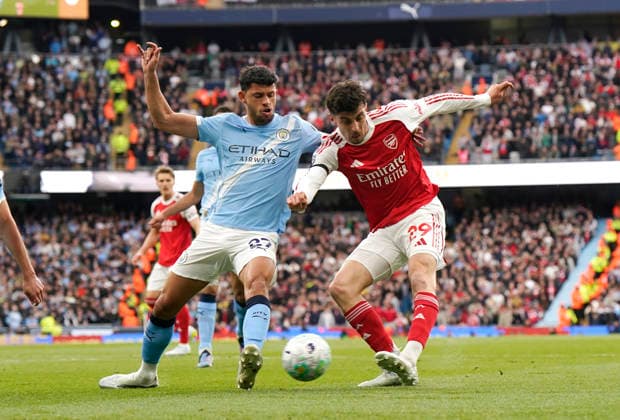 Manchester, England, 19th April 2026. Matheus Nunes of Manchester City (l) blocks a shot by Kai Havertz of Arsenal (r) during the Manchester City vs Arsenal Premier League match at the Etihad Stadium, Manchester. Picture credit should read: Andrew Yates Sportimage EDITORIAL USE ONLY. No use with unauthorised audio, video, data, fixture lists, club league logos or live services. Online in-match use limited to 120 images, no video emulation. No use in betting, games or single club league player publications. SPI_039_AY_Man_City_Arsenal SPI-4704-0039