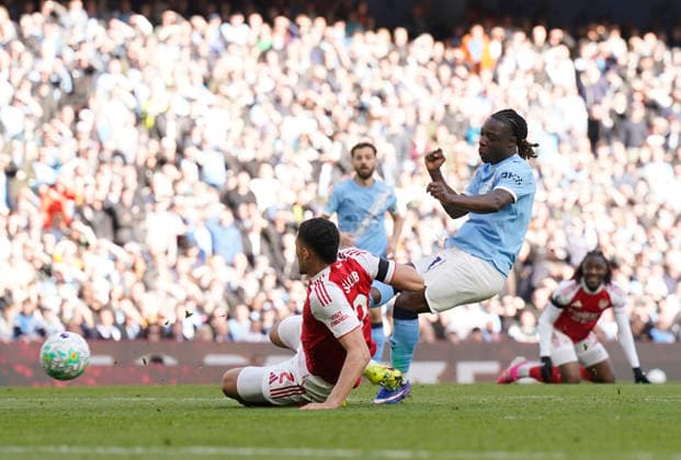 Manchester, England, 19th April 2026. Jeremy Doku of Manchester City has a shot saved during the Manchester City vs Arsenal Premier League match at the Etihad Stadium, Manchester. Picture credit should read: Andrew Yates Sportimage EDITORIAL USE ONLY. No use with unauthorised audio, video, data, fixture lists, club league logos or live services. Online in-match use limited to 120 images, no video emulation. No use in betting, games or single club league player publications. SPI_078_AY_Man_City_Arsenal SPI-4704-0077