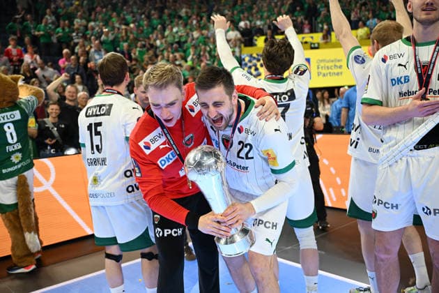 GER, Lanxess Arena Koeln, HBL, LIDL FINAL4, Men, Finale, Fuechse Berlin vs. bergischer HC 19.04.2026, Lanxess Arena , Koeln , GER, Lanxess Arena Koeln, HBL, LIDL FINAL4, Men, Finale, Fuechse Berlin vs. bergischer HC, im Bild: die Fuechse Berlin sind Deutscher Pokalsieger 2026 und stehen auf dem Podest und bejubeln den Titel mit dem Pokal vor den Zuschauern