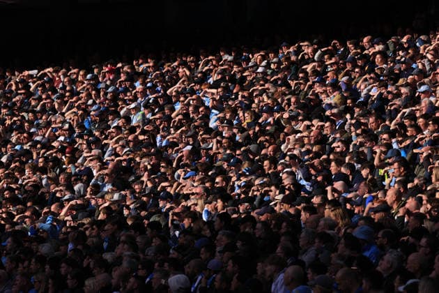 Football - Premier League - Manchester City v Arsenal 19th April 2026 - Premier League - Manchester City v Arsenal - Manchester City fans shield their eyes against the sun - Photo: Simon Stacpoole Offside. Manchester UK Copyright: xSimonxStacpoolexOffside