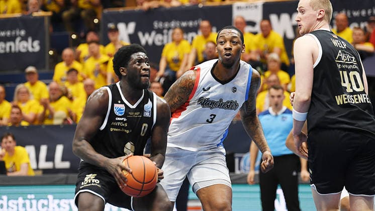 Basketball, ENBL VIMODROM Final Four 2026, Halbfinale, SYNTAINICS MBC (Mitteldeutscher Basketball Club Weissenfels) vs. Manchester Basketball (22.04.2026) 86:89 (49:42) Zweikampf um den Ball zwischen Khyri Thomas (Guard Syntainics MBC, Rückennummer 0) (li.) und Gabe Osabuohien (Forward Manchester Basketball, Rückennummer 3) (Mitte) beim Spiel MBC Weißenfels gegen Manchester Basketball (22.04.2026) Weißenfels Sachsen-Anhalt Deutschland Stadthalle Weißenfels