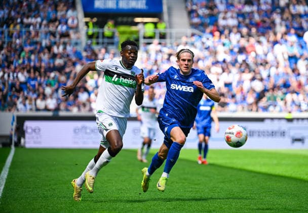 Mustapha Bundu (Hannover 96) und David Herold (Karlsruher SC) im Zweikampf waehrend des Spiels der 2. Bundesliga zwischen dem Karlsruher SC und Hannover 96 im BBBank Wildpark am 25. April 2026 in Karlsruhe, Deutschland. (Foto von Silas Schüller DeFodi Images) +++ Mustapha Bundu (Hannover 96) and David Herold (Karlsruher SC) battle for the ball during the 2. Bundesliga match between Karlsruher SC and Hannover 96 at BBBank Wildpark on April 25, 2026 in Karlsruhe, Germany. (Photo by Silas Schüller DeFodi Images) DFB DFL REGULATIONS PROHIBIT ANY USE OF PHOTOGRAPHS AS IMAGE SEQUENCES AND OR QUASI-VIDEO. (Photo by Silas Schueller DeFodi Images) -