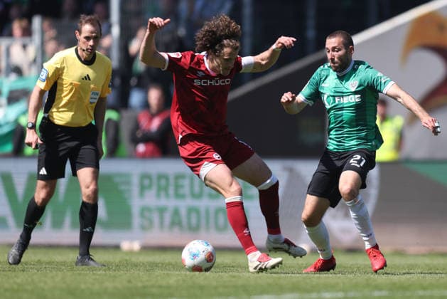 Fußball 2. Bundesliga 31. Spieltag SC Preußen Münster - DSC Arminia Bielefeld am 25.04.2026 im LVM-Preußenstadion in Münster Mael Corboz ( Bielefeld ), links - Rico Preißinger ( Münster ), rechts DFL regulations prohibit any use of photographs as image sequences and or quasi-video.