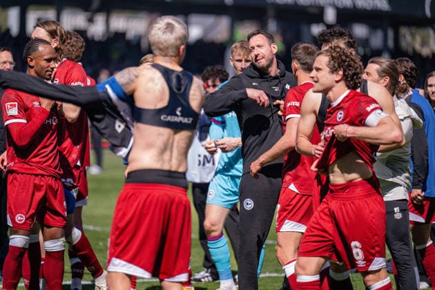 25.04.2026, Fussball, 2. Bundesliga, 31. Spieltag Saison 2025 2026, Preußen Münster - DSC Arminia Bielefeld, Die Spieler von Arminia Bielefeld freuen sich über den Sieg, Trainer Mitch Kniat (Arminia Bielefeld) schickt die Spieler zu den Fans, xRHR-FOTO TKx *** 25 04 2026, Soccer, 2 Bundesliga, 31 Matchday Season 2025 2026, Preußen Münster DSC Arminia Bielefeld, The players of Arminia Bielefeld are happy about the victory, Coach Mitch Kniat Arminia Bielefeld sends the players to the fans, xRHR PHOTO TKx Copyright: RHR-FOTOx RHR-FOTO TK