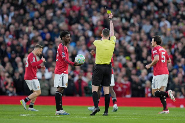 27th April 2026; Old Trafford, Manchester, England; Premier League Football, Manchester United, ManU versus Brentford; Referee, Chris Kavanagh shows a yellow card to Luke Shaw of Manchester United StevexFlynn