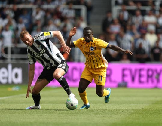 Newcastle Upon Tyne, England, 2nd May 2026. Dan Burn (L) of Newcastle United in action with Yankuba Minteth of Brighton and Hove Albion during the Newcastle United vs Brighton and Hove Albion Premier League match at St. James Park, Newcastle Upon Tyne. Picture credit should read: Nigel Roddis Sportimage EDITORIAL USE ONLY. No use with unauthorised audio, video, data, fixture lists, club league logos or live services. Online in-match use limited to 120 images, no video emulation. No use in betting, games or single club league player publications. SPI_023_NR_NEWC_BRIG SPI-4784-0009