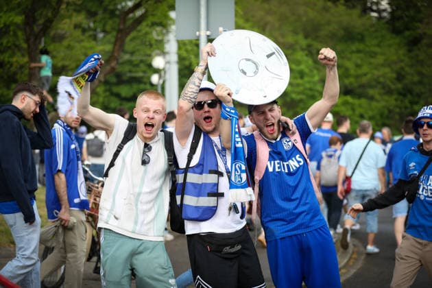 Deutschland: Fussball 2. Bundesliga 2025 - 2026, 32. Spieltag - FC Schalke 04 vs Fortuna Düsseldorf - Veltins Arena (Schalke): Gelsenkirchen, Deutschland, Europa, Schalke 04 Fans, Fanmarsch, Porträt, jubelnde Anhänger, Meisterschale, erhobene Arme, Emotionen, Fußballbegeisterung, blau-weiß, Trikots, Schals, Nordkurve, Supporters, Spieltag, Bundesliga, Ruhrgebiet, Fankultur, Straßenumzug, Event, Medieninteresse