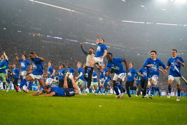 Deutschland: Fussball 2. Bundesliga 2025 - 2026, 32. Spieltag - FC Schalke 04 vs Fortuna Düsseldorf - Veltins Arena (Schalke): Aufstieg Bundesliga, Spielerjubel, Miron Muslic (Trainer, Schalke 04) Platzsturm, Team feiert, Emotionen, Ekstase, Jubelszenen, Rutschen auf dem Rasen, blaue Shirts, Rauf geht™s Schalke, Mannschaft, Fußball, 2. Bundesliga, Matchday, Stadion, Fans im Hintergrund, Party, Sieg, Sportevent, Teamspirit, unten, Froschperspektive