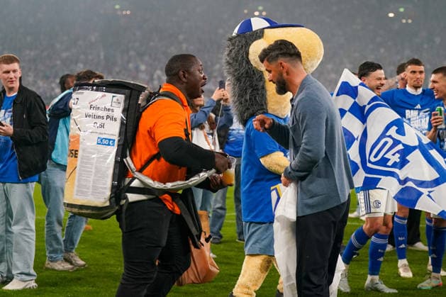 Deutschland: Fussball 2. Bundesliga 2025 - 2026, 32. Spieltag - FC Schalke 04 vs Fortuna Düsseldorf - Veltins Arena (Schalke): Miron Muslic (Trainer, Schalke 04) Bierverkäufer, Veltins Pils, Maskottchen Erwin, Platz, Aufstieg, Feier, Emotionen, Fußball, 2. Bundesliga, Spieler, Fans, Fahne, Vereinsfarben blau-weiß, Stadionatmosphäre, Jubel, Event, Sportfotografie, Medienbild