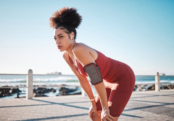 Fitness, music and exhausted with a black woman runner on the promenade for cardio or endurance training. Exercise, running and earphones with a sports person feeling tired during her workout. (License=RF) 19837953 ,model released, Symbolfoto  Copyright: xZoonar.com YurixArcursxpeopleimages.comx 19837953 ,model released, Symbolfoto ,property released