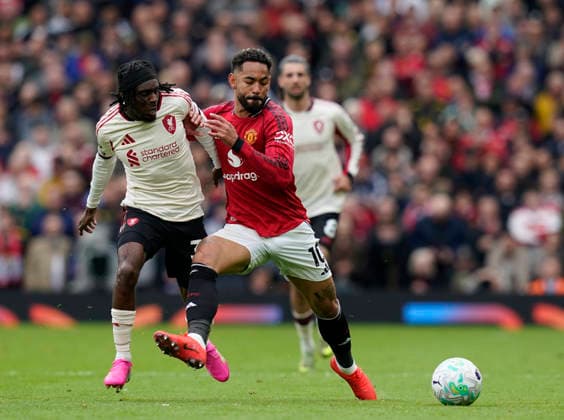 Manchester, England, 3rd May 2026. Jeremie Frimpong of Liverpool tussles with Matheus Cunha of Manchester United, ManU during the Manchester United vs Liverpool Premier League match at Old Trafford, Manchester. Picture credit should read: Andrew Yates Sportimage EDITORIAL USE ONLY. No use with unauthorised audio, video, data, fixture lists, club league logos or live services. Online in-match use limited to 120 images, no video emulation. No use in betting, games or single club league player publications. SPI_062_AY_MAN_UTD_LIVERPOOL SPI-4776-0061