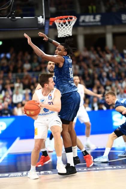Osun Osunniyi (12; MLP Academics Heidelberg) und Mateo Seric (21; MLP Academics Heidelberg) verteidigen gegen Spencer Reaves (31; Syntainics MBC) mit Ball im SNP Dome Verteidigungsszene mit Osun Osunniyi (12; MLP Academics Heidelberg) und Mateo Seric (21; MLP Academics Heidelberg) Copyright: xMichaelxGelhardtx