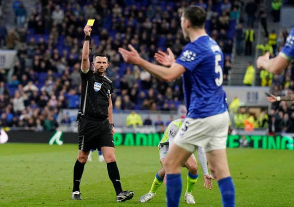 Liverpool, England, 4th May 2026. Referee Michael Oliver issues a yellow card fo Michael Keane of Everton for a tackle on Jeremy Doku of Manchester City during the Everton vs Manchester City Premier League match at Hill Dickinson Stadium, Liverpool. Picture credit should read: Andrew Yates Sportimage EDITORIAL USE ONLY. No use with unauthorised audio, video, data, fixture lists, club league logos or live services. Online in-match use limited to 120 images, no video emulation. No use in betting, games or single club league player publications. SPI_023_AY_Everton_Man_City SPI-4779-0023
