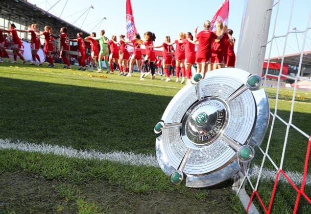 Fussball, Frauen, Google Pixel Frauen Bundesliga, 25.Spieltag, Saison 2025 2026, FC Bayern München - Eintracht Frankfurt, Campus Die Meisterfeier nach dem Spiel, hier die Mannschaft des FC Bayern München Frauen, hier lehnt die Meisterschale am Torpfosten während die Mädls Feiern