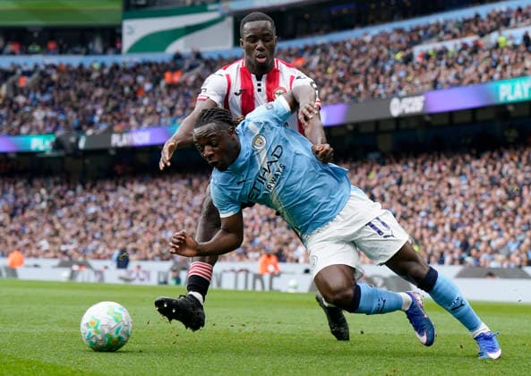 Manchester, England, 9th May 2026. Jeremy Doku of Manchester City (R) is challenged by Michael Kayode of Brentford during the Manchester City vs Brentford Premier League match at the Etihad Stadium, Manchester. Picture credit should read: Andrew Yates Sportimage EDITORIAL USE ONLY. No use with unauthorised audio, video, data, fixture lists, club league logos or live services. Online in-match use limited to 120 images, no video emulation. No use in betting, games or single club league player publications. SPI_012_AY_MAN_CITY_BRENTFORD SPI-4788-0016