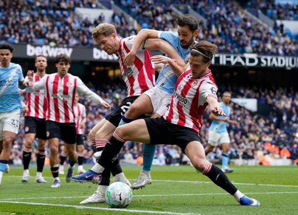 Manchester, England, 9th May 2026. Bernardo Silva of Manchester City (c) is challenged by Mathias Jensen of Brentford and Nathan Collins of Brentford during the Manchester City vs Brentford Premier League match at the Etihad Stadium, Manchester. Picture credit should read: Andrew Yates Sportimage EDITORIAL USE ONLY. No use with unauthorised audio, video, data, fixture lists, club league logos or live services. Online in-match use limited to 120 images, no video emulation. No use in betting, games or single club league player publications. SPI_013_AY_MAN_CITY_BRENTFORD SPI-4788-0017