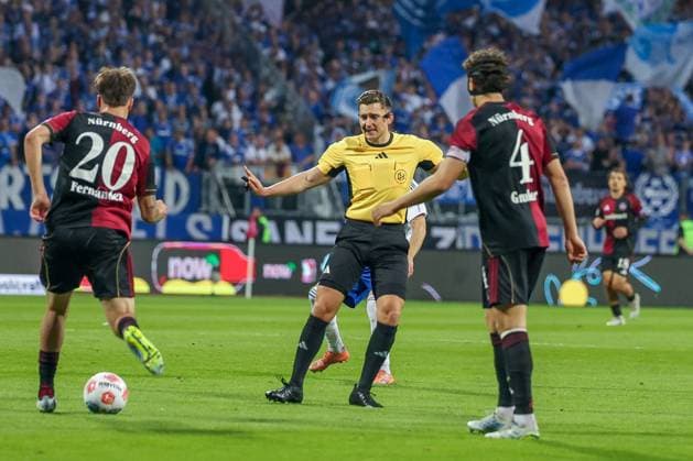 Referee Schiedsrichter Felix Prigan gestikiuliert, mit Javier Fernandez 20 (1FC Nuernberg) und Fabio Gruber 4 (1FC Nuernberg), 1. FC Nuernberg vs. FC Schalke 04, Fussball, Maenner, 2. Bundesliga, DFL, Saison 2025 2026, 33. Spieltag, Rueckrunde, 09.05.2026 DFB regulations prohibit any use of photographs as image sequences and or quasi-video Nuernberg Bayern Deutschland