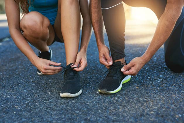 Tie up and hit the road together. a couple tying their shoelaces while out for a run (License=RF) 20262259 ,model released, Symbolfoto  Copyright: xZoonar.com KasperxRavlox 20262259 ,model released, Symbolfoto ,property released