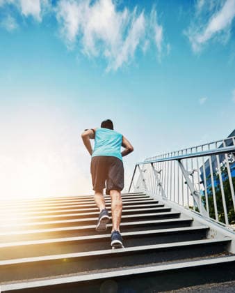 Back, fitness and running with man, stairs and exercise with progress, sunshine and challenge. Rear view, steps and runner in city, lens flare or training for wellness, healthy or energy with workout. (License=RF) 21848710 ,model released, Symbolfoto  Copyright: xZoonar.com KasperxRavlox 21848710 ,model released, Symbolfoto ,property released
