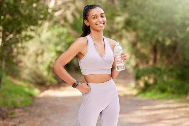 Woman, bottle and outdoor in portrait with smile for exercise, workout or running in the forest. Happy, female person or athlete in nature for fitness, training and health with water drink to relax. (License=RF) 21870626 ,model released, Symbolfoto  Copyright: xZoonar.com KasperxRavlox 21870626 ,model released, Symbolfoto ,property released