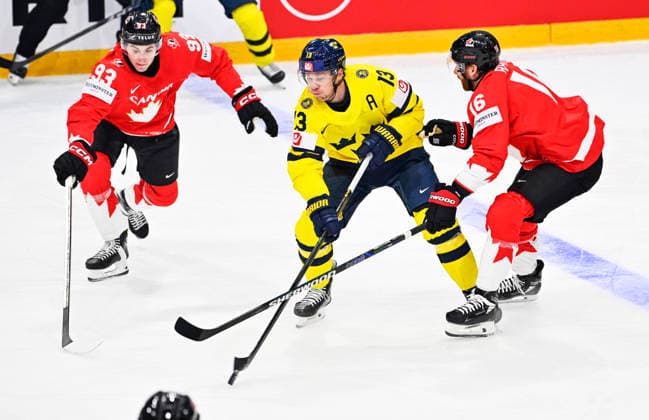 FRIBOURG, SCHWEIZ 20260515 Kanadas Fraser Minten och Connor Brown mot Sveriges Lucas Raymond under premiärmatchen i ishockey-VM mellan Kanada och Sverige pa BCF Arena, Fribourg i Schweiz.