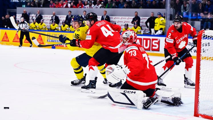 FRIBOURG, SCHWEIZ 20260515 Sveriges Jack Berglund mot Kanadas Morgan Rielly, malvakt Jet Greaves och Dylan DeMelo under premiärmatchen i ishockey-VM mellan Kanada och Sverige pa BCF Arena, Fribourg i Schweiz.