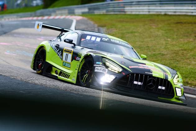 Der Mercedes-AMG GT3 mit der Startnummer 11 von SR Motorsport by Schnitzelalm durchfährt eine Kurve auf der Nordschleife des Nürburgrings. Das in Schwarz und Neongrün gehaltene Fahrzeug Jannes Fittje & Jay Mo Härtling & Kenneth Heyer & Philip Ellis (SR Motorsport by Schnitzelalm) ist mit Sponsoren wie RAVENOL, Goodyear und H&R beklebt und zeigt im dynamischen Fahrtmoment die typische Curbs-Begrenzung der legendären Strecke. Mercedes-AMG GT3 11 von SR Motorsport by Schnitzelalm auf der Nordschleife