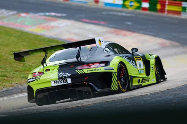 Der Mercedes-AMG GT3 mit der Startnummer 11 von SR Motorsport by Schnitzelalm durchfährt eine Kurve auf der Nordschleife des Nürburgrings. Das auffällig schwarz-gelbgrüne Fahrzeug Jannes Fittje & Jay Mo Härtling & Kenneth Heyer & Philip Ellis (SR Motorsport by Schnitzelalm) trägt die Sponsoren Schnitzel-Alm, Goodyear, RAVENOL und H&R und bietet eine dynamische Heckansicht mit großem Heckflügel. Mercedes-AMG GT3 11 von SR Motorsport by Schnitzelalm auf der Nordschleife