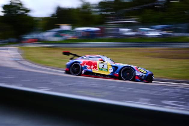 Der Mercedes-AMG GT3 mit der Startnummer 3 des Mercedes-AMG Team Verstappen Racing durchfährt eine Kurve auf dem Nürburgring. Das Fahrzeug Daniel Juncadella & Jules Gounon & Lucas Auer & Max Verstappen (Mercedes-AMG Team Verstappen Racing) trägt das markante Red-Bull-Design in Blau, Rot und Gelb mit RAVENOL- und DEKRA-Sponsoring. Die Panning-Aufnahme unterstreicht die hohe Geschwindigkeit des GT3-Fahrzeugs beim ADAC RAVENOL 24h Nürburgring 2026. Mercedes-AMG GT3 3 von Verstappen Racing auf der Nordschleife