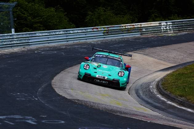 Der türkisfarbene Porsche 911 GT3 R von Falken Motorsports mit der Startnummer 44 durchfährt eine enge Kurve auf der Nordschleife des Nürburgrings. Das Fahrzeug trägt die markante Falken-Bereifung und ist mit Sponsoren wie H&R sowie Gran Turismo beklebt. Klaus Bachler & Morris Schuring & Sven Müller & Tim Heinemann (Falken Motorsports) Falken Porsche 911 GT3 R durchfährt enge Kurve auf der Nordschleife