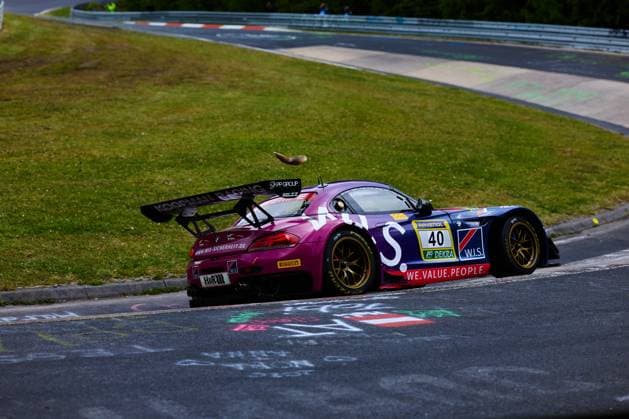 Der BMW M6 GT3 mit der Startnummer 40 des Teams W.I.S Racing Team powered by Koopman Racing durchfährt eine Kurve auf der Nordschleife am Nürburgring. Das in Lila und Dunkelblau gehaltene Fahrzeug trägt die Sponsoren RAVENOL, DEKRA, W.I.S, H&R und Pirelli. Auf dem Fahrzeug ist ein Eichhörnchen zu sehen, das offenbar gerade über das Dach des Rennwagens springt – ein ungewöhnlicher Moment im Renneinsatz. Frank Nikolaus & Michael Funke & Peter Posavac & Volker Strycek (W.I.S Racing Team powered by Koopman Racing) BMW M6 GT3 40 von W.I.S Racing auf der Nordschleife