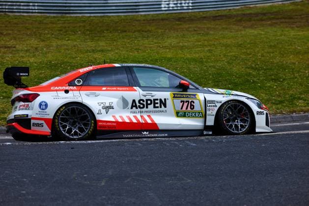 Der Audi RS 3 LMS mit der Startnummer 776 des Teams sharky-racing.com durchfährt eine Kurve auf dem Nürburgring. Das in Weiß und Rot gehaltene Fahrzeug Gian Maria Gabbiani & Ivars Vallers & Mikaela Ahlin-Kottulinsky & Philipp Eis (sharky-racing.com) trägt die Hauptsponsoren ASPEN Fuel for Professionals sowie RAVENOL auf der Startnummerntafel und ist mit Goodyear Eagle-Reifen ausgestattet. Weitere Sponsoren wie Bosch, PBS, Carrera und Markthalle Königshof zieren die Karosserie des Audi Fahrzeugs. Audi RS 3 LMS 776 von sharky-racing.com auf dem Nürburgring